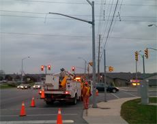 crews replacing one of 13 traffic signal heads knocked down by strong winds in November, 2013