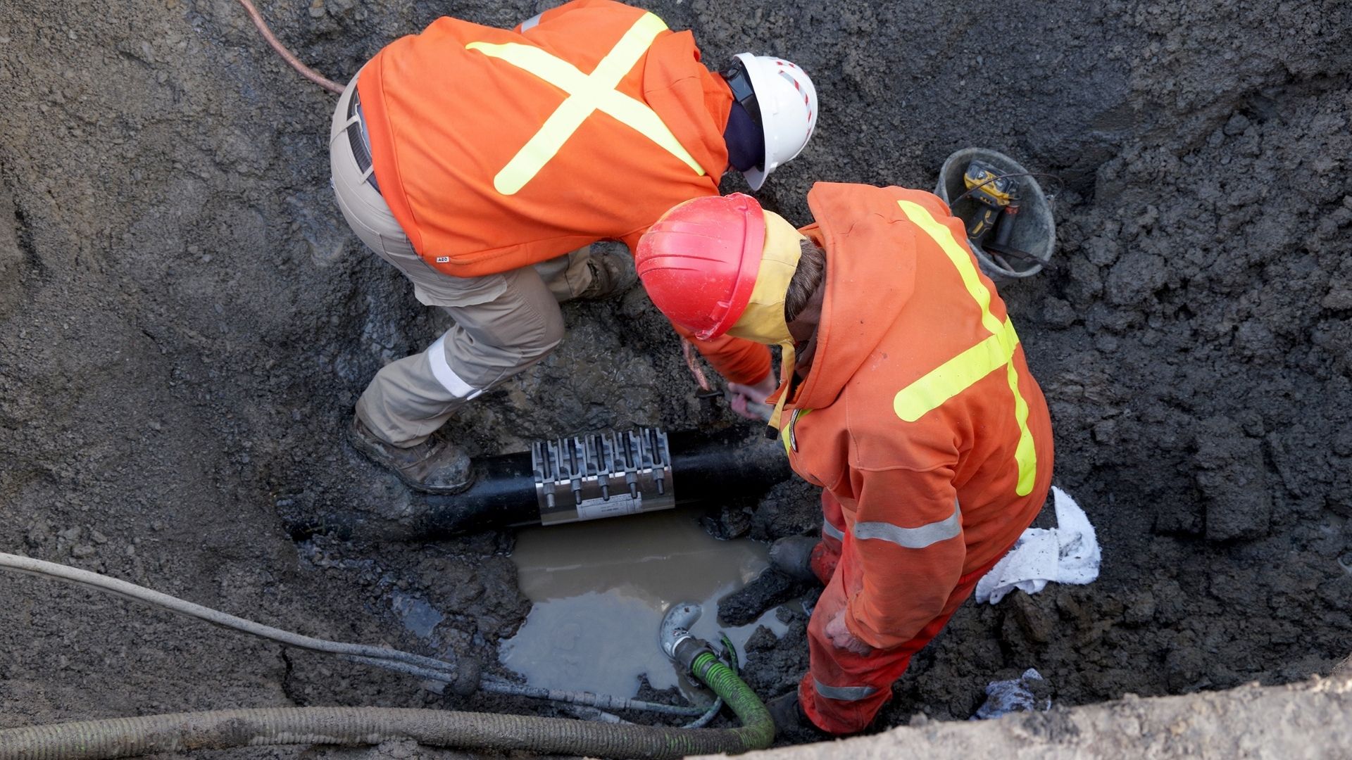 illustrative photo of operators repairing a water main