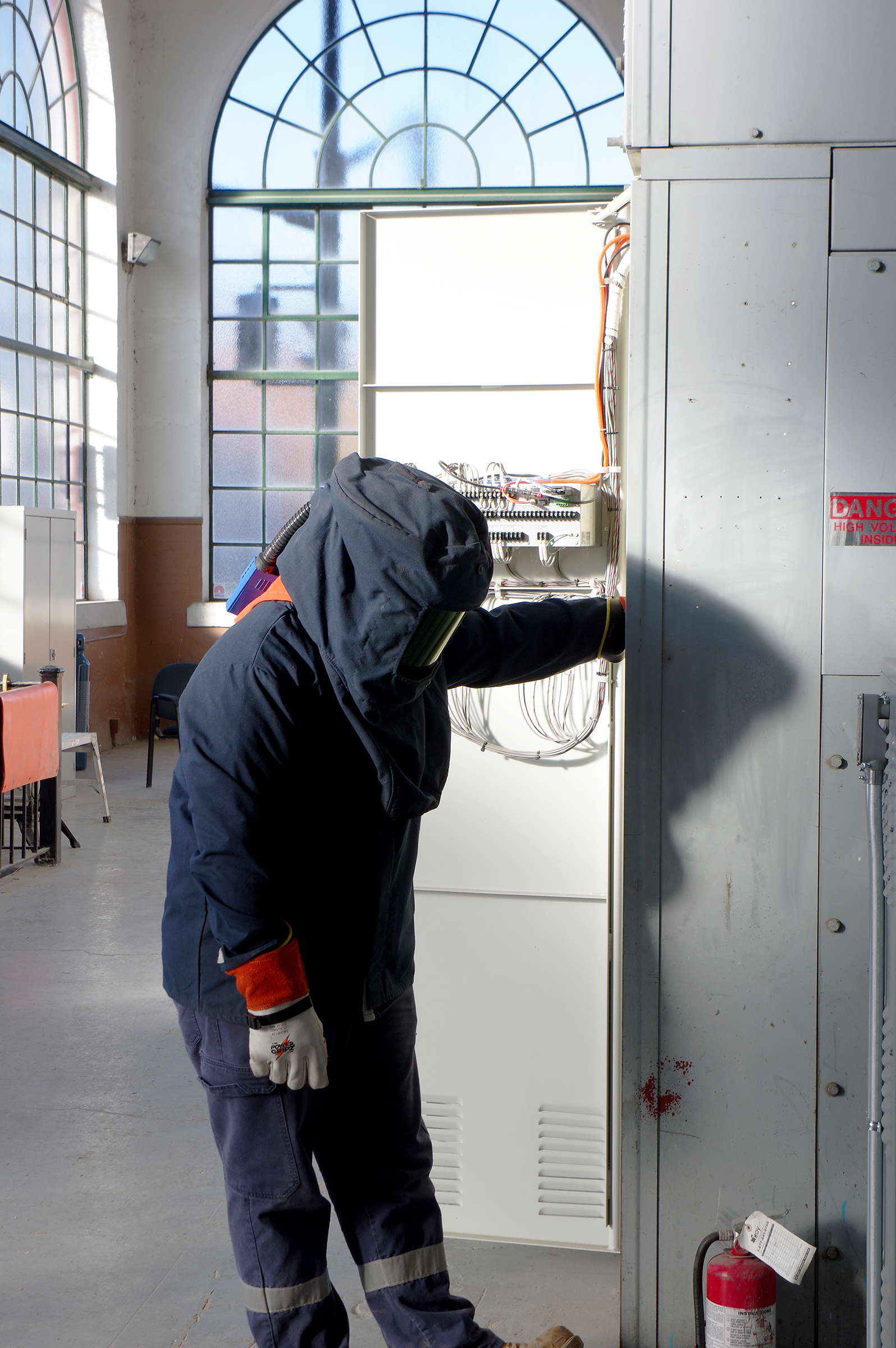 	A Utilities Kingston journeyperson wears a category 4 arc flash suit, while energizing the station.