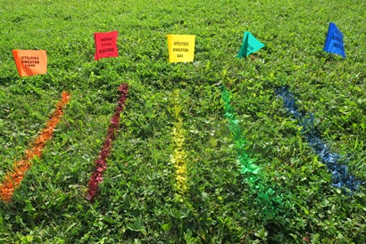 Locating flags that mark the utility: fibre network (orange) and municipal electricity and streetlights (red), natural gas (yellow), sewer (green) and water (blue) utilities.