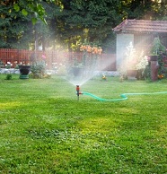 sprinkler watering a lawn and garden
