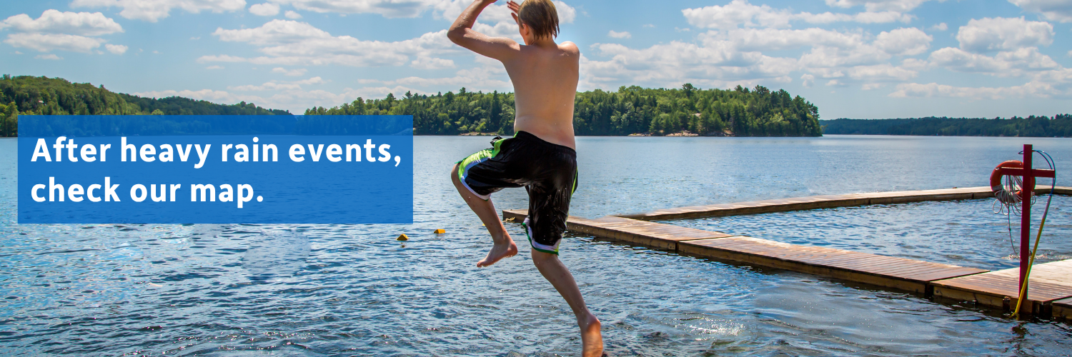 Teenager is jumping off a dock into the lake in the summer