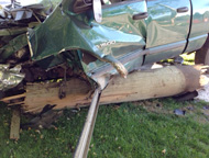 crumpled car and broken utility pole