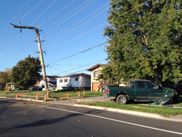A broken pole and a car involved in a single motor vehicle accident.